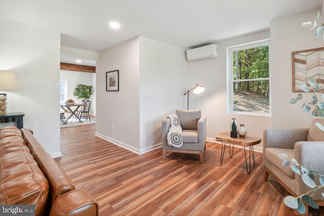 living room featuring a wall mounted AC and hardwood / wood-style flooring