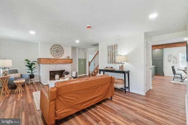 living room with a fireplace, plenty of natural light, and light hardwood / wood-style floors