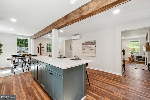 kitchen featuring a kitchen breakfast bar, a kitchen island, dark hardwood / wood-style flooring, beamed ceiling, and a wall unit AC