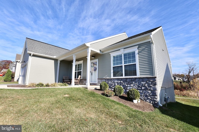 ranch-style house with stone siding, covered porch, and a front yard