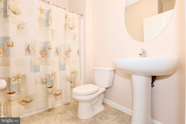 bathroom with toilet, walk in shower, and tile patterned flooring