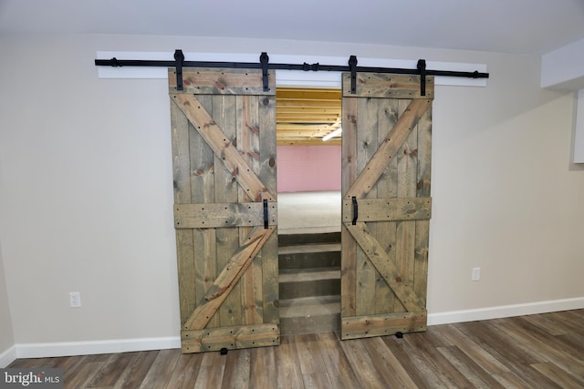 interior space with a barn door and wood-type flooring