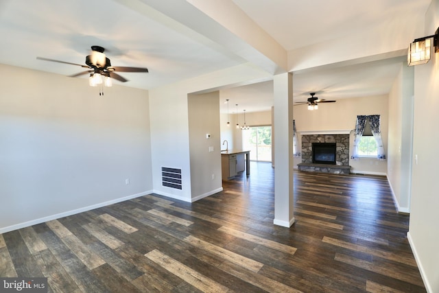 unfurnished living room with ceiling fan, dark hardwood / wood-style floors, and a fireplace