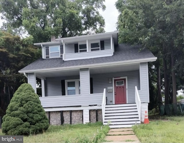 bungalow-style house with a porch, a chimney, and roof with shingles