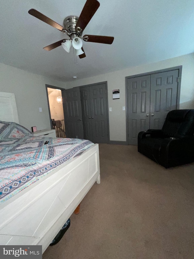 bedroom with carpet flooring, two closets, and ceiling fan