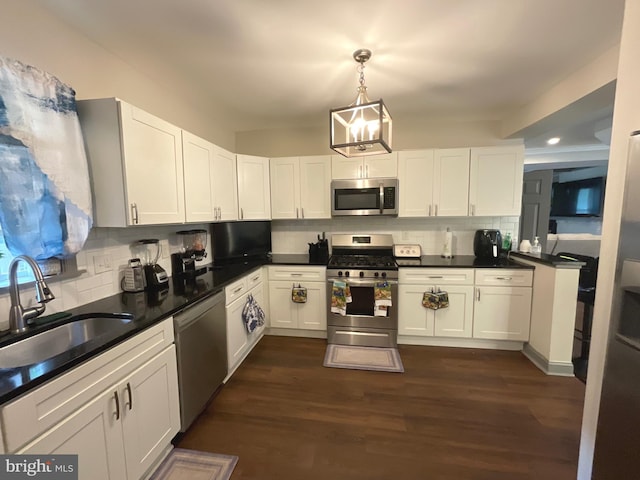 kitchen with a sink, backsplash, appliances with stainless steel finishes, and white cabinets