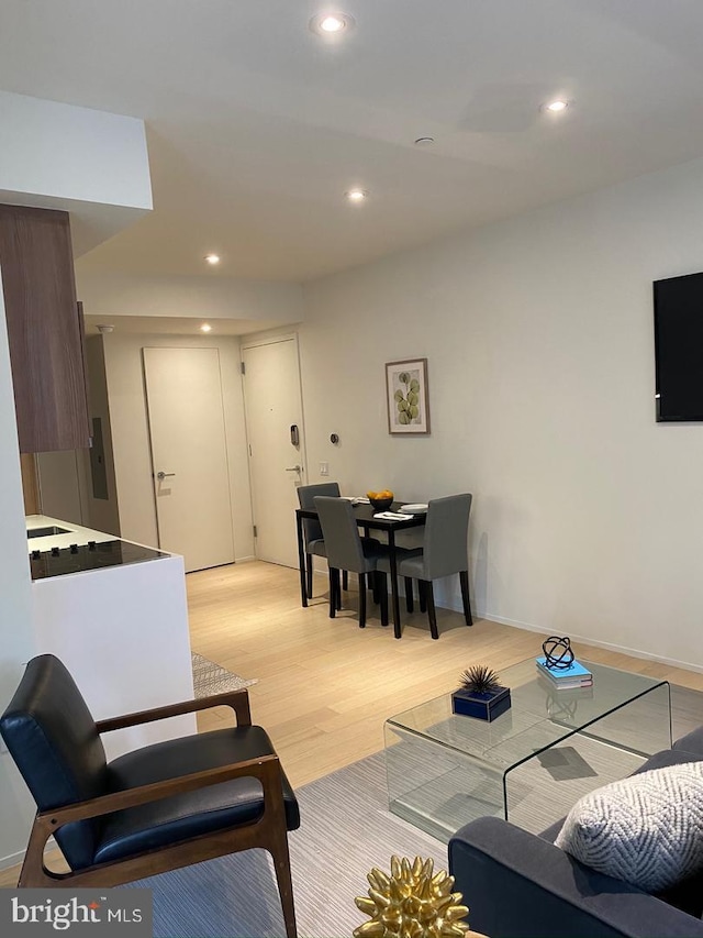 living area featuring light wood-type flooring, recessed lighting, and baseboards