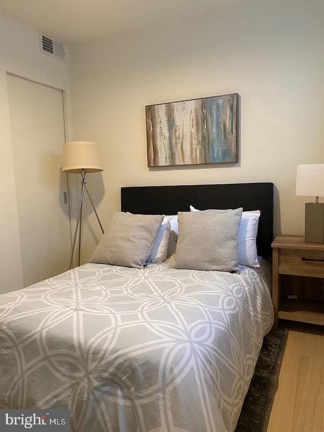 bedroom with visible vents and wood finished floors