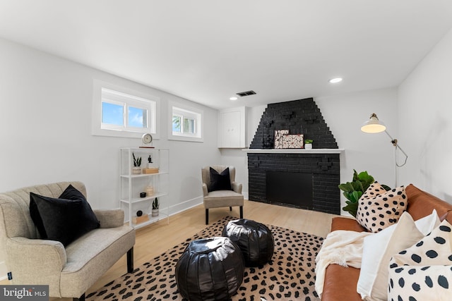 living room featuring light wood-type flooring and a fireplace