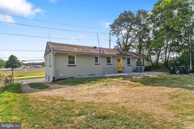 back of property with central air condition unit and a yard