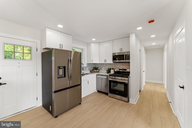 kitchen featuring a wealth of natural light, stainless steel appliances, and white cabinets