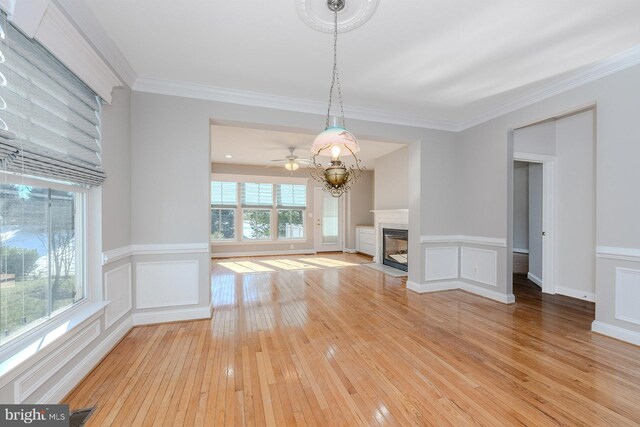 kitchen featuring ornamental molding, light wood-style floors, stainless steel gas stovetop, white cabinets, and baseboards