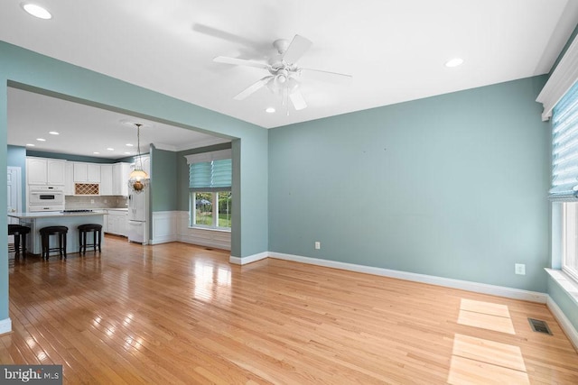 unfurnished living room featuring visible vents, baseboards, ceiling fan, light wood-type flooring, and recessed lighting