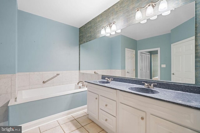 bathroom with a bathtub, vanity, and tile patterned floors