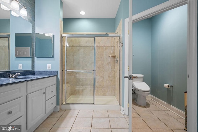 bathroom with tile patterned flooring, vanity, toilet, and a shower with shower door