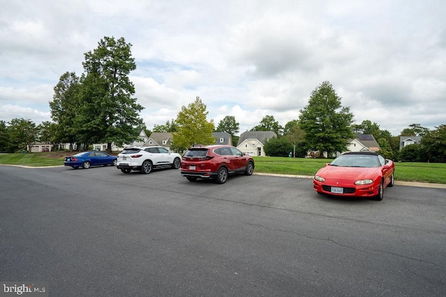 view of parking / parking lot featuring a lawn