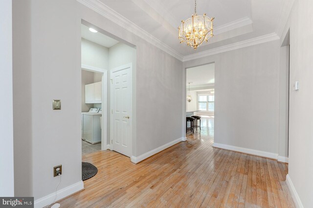 foyer with ornamental molding, an inviting chandelier, and light hardwood / wood-style floors