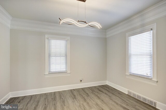 empty room with crown molding and hardwood / wood-style flooring