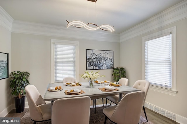 dining space with dark hardwood / wood-style flooring and ornamental molding