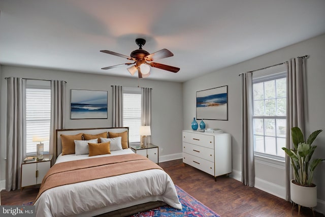 bedroom with multiple windows, ceiling fan, and dark wood-type flooring