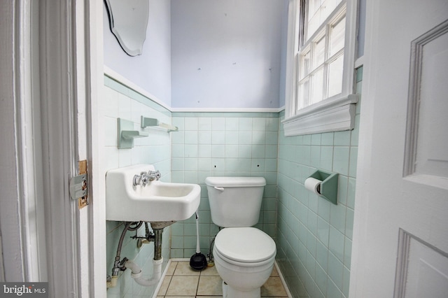 bathroom featuring tile walls, tile patterned flooring, toilet, and sink