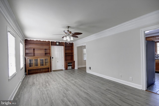 unfurnished living room with ceiling fan, wood-type flooring, and ornamental molding