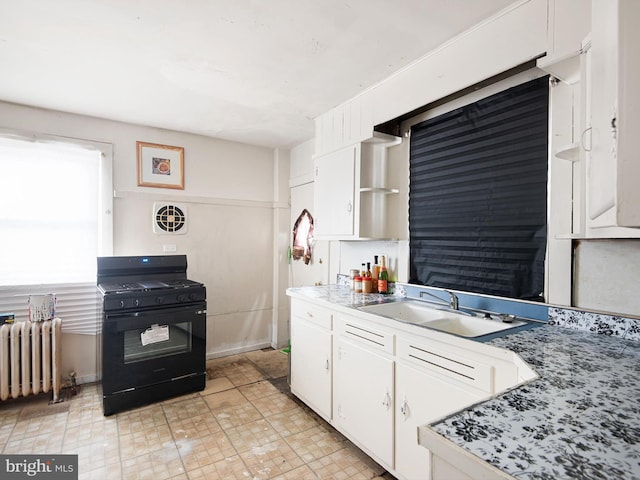 kitchen with white cabinetry, black range with gas cooktop, and radiator