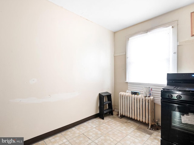 kitchen with radiator heating unit and black range with gas cooktop