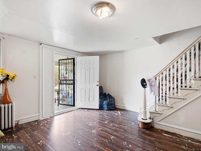 foyer entrance featuring dark hardwood / wood-style flooring and radiator heating unit