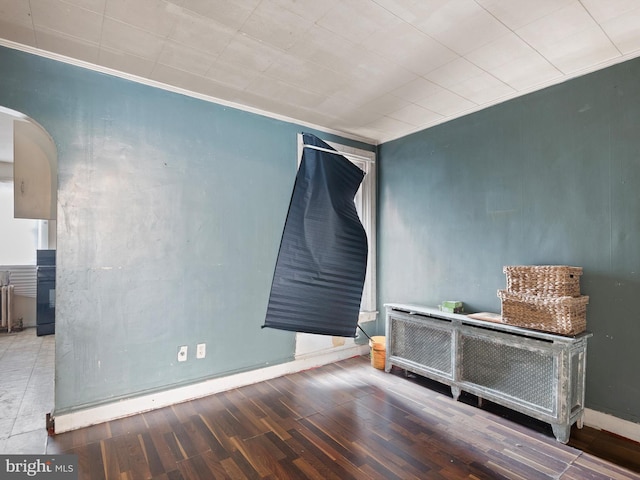 spare room featuring crown molding and hardwood / wood-style floors