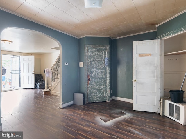 entryway with crown molding and dark wood-type flooring