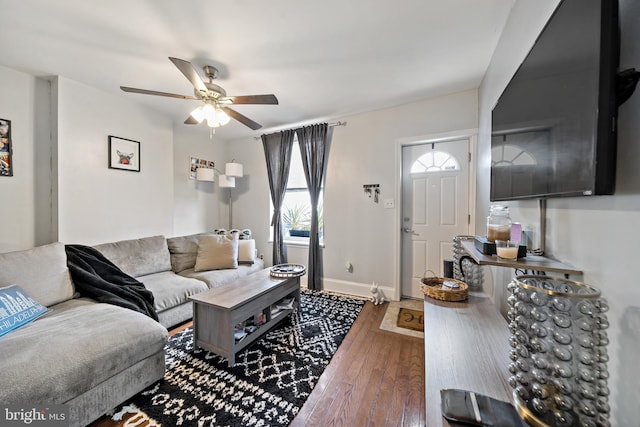 living room with ceiling fan and dark hardwood / wood-style flooring