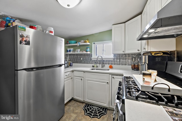 kitchen with tasteful backsplash, white cabinets, sink, appliances with stainless steel finishes, and range hood