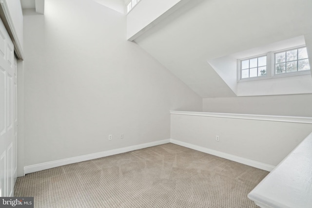 bonus room with light carpet and lofted ceiling