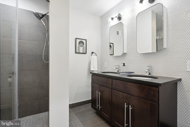 bathroom featuring vanity, backsplash, tile patterned flooring, and tiled shower