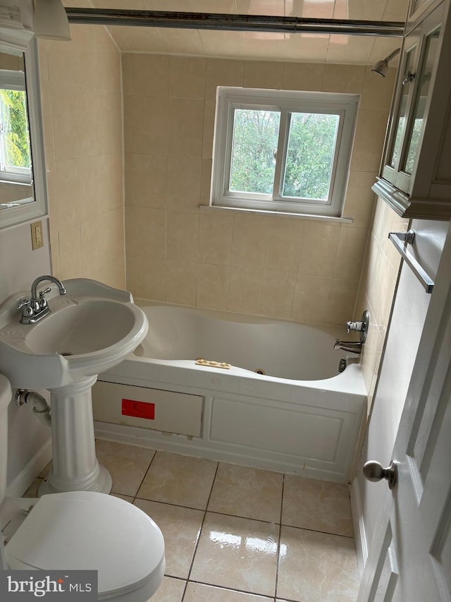 bathroom with toilet, plenty of natural light, and tile patterned floors