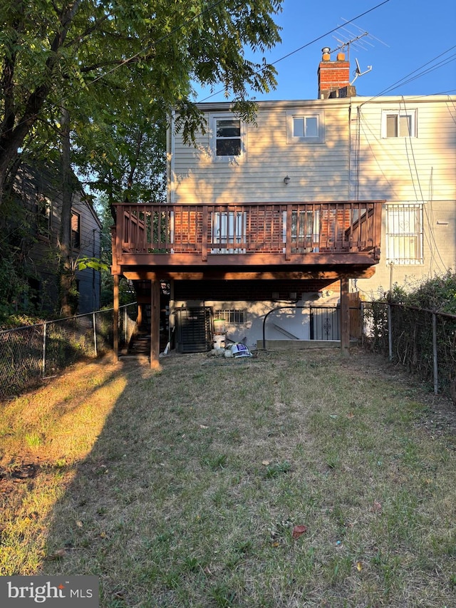 back of property with central AC, a yard, and a wooden deck