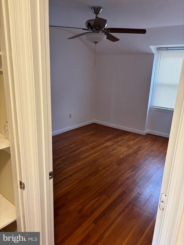 spare room featuring ceiling fan, dark hardwood / wood-style floors, and vaulted ceiling