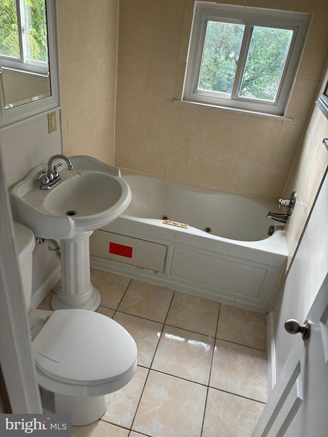 bathroom with toilet, tile patterned flooring, and a bathtub