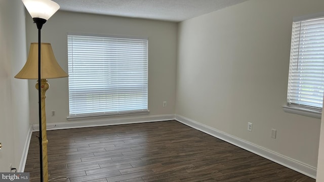 unfurnished room featuring a textured ceiling and dark wood-type flooring