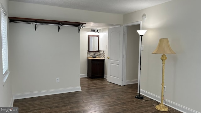 interior space with a textured ceiling and dark hardwood / wood-style floors