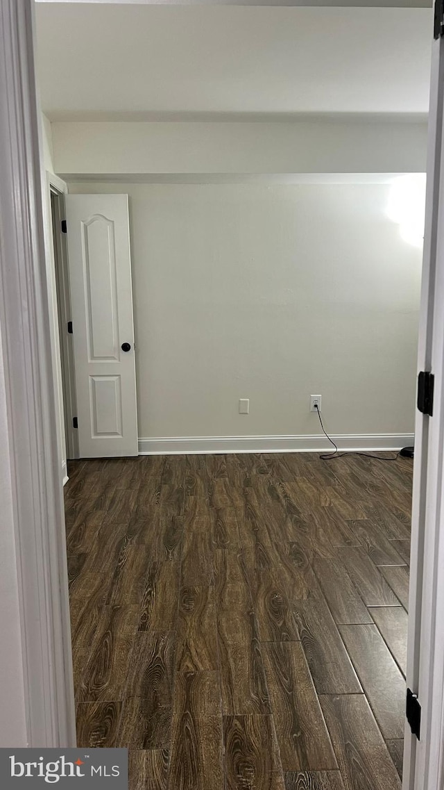 unfurnished room featuring dark wood-type flooring