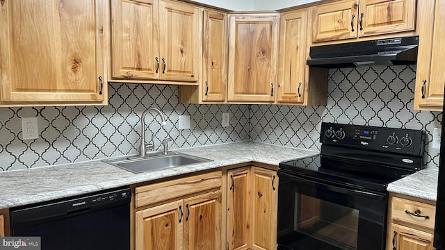 kitchen with black appliances, under cabinet range hood, a sink, light countertops, and decorative backsplash