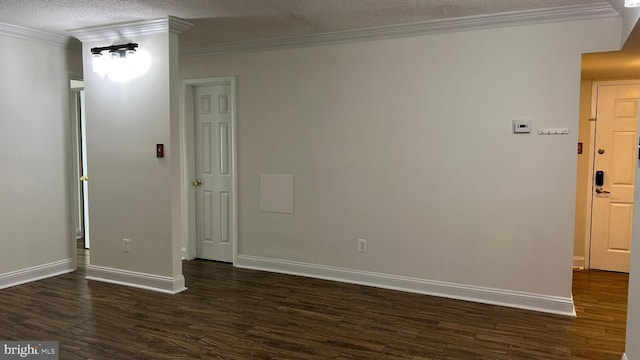 spare room with a textured ceiling, crown molding, and dark hardwood / wood-style flooring