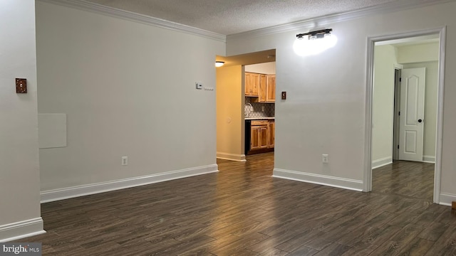 spare room with a textured ceiling, ornamental molding, and dark hardwood / wood-style flooring