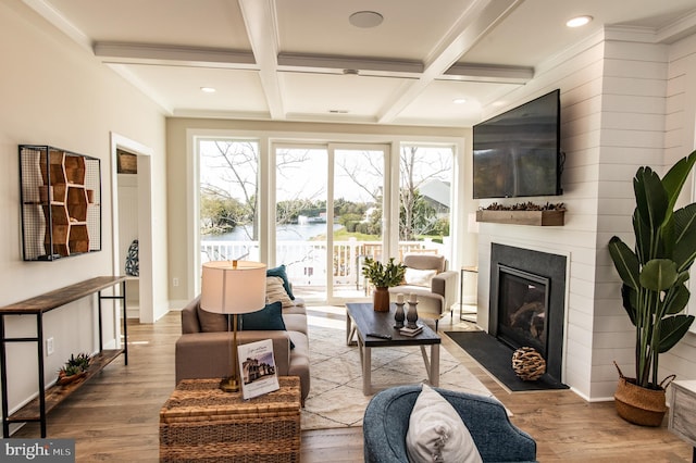 living room with coffered ceiling, ornamental molding, beamed ceiling, and light wood-type flooring