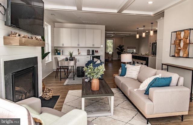 living room with crown molding, coffered ceiling, sink, and light wood-type flooring