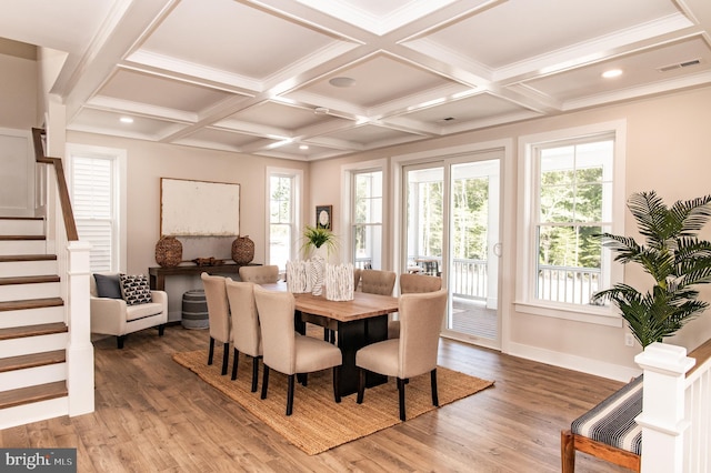 dining room with a healthy amount of sunlight, coffered ceiling, and hardwood / wood-style flooring