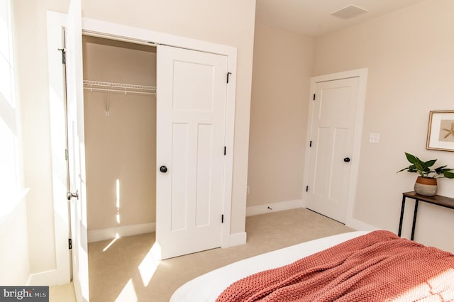 bedroom with a closet and light carpet