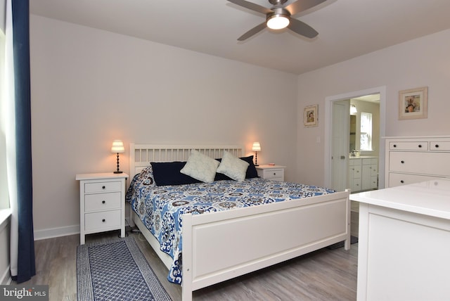 bedroom with ensuite bath, ceiling fan, and dark hardwood / wood-style flooring